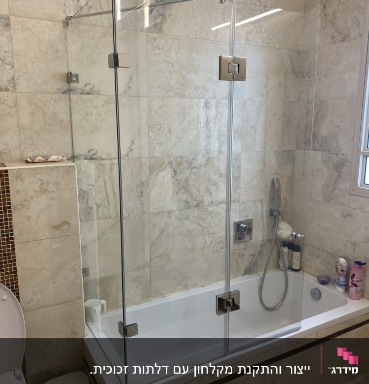 מקלחון זכוכית עם אמבטיה, ברז ומוצרי טיפוח